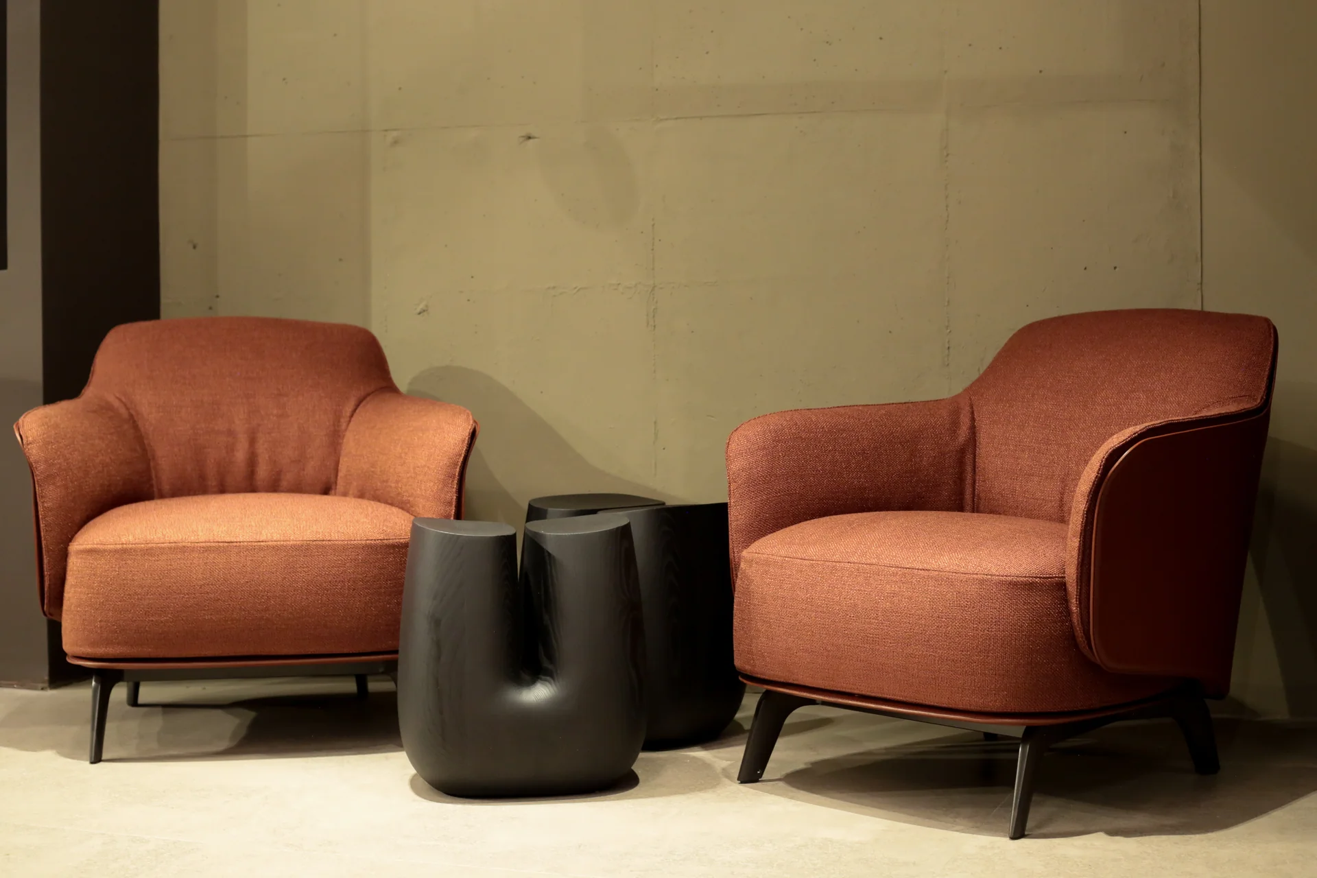 Sillones Poliform en cuero terracota con mesa baja escultórica negra · showroom Productos Arquitectónicos en Bogotá