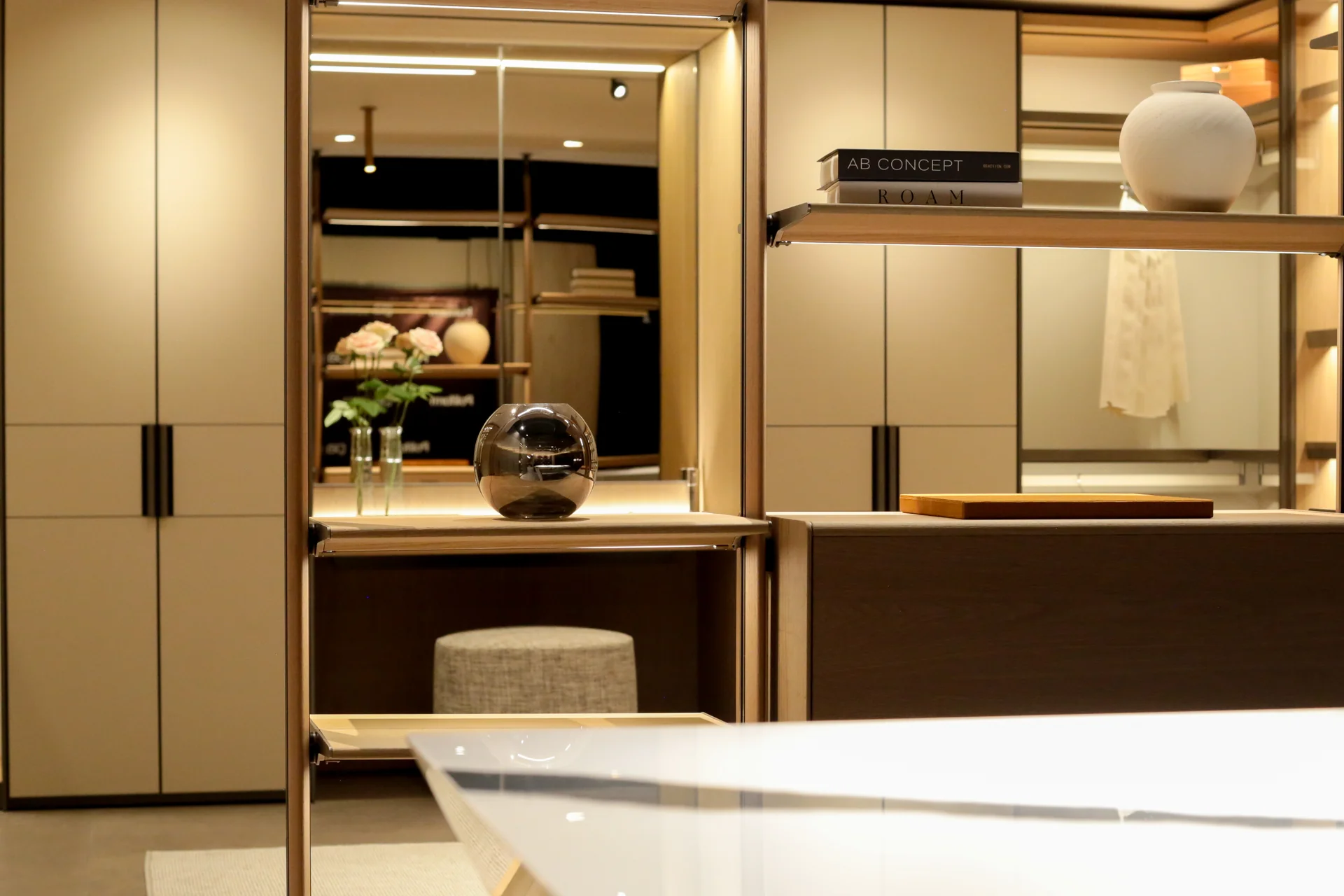 Detalle del walking closet Poliform con mesón en mármol blanco veteado y curaduría de objetos · diseño interior por César Serrano
