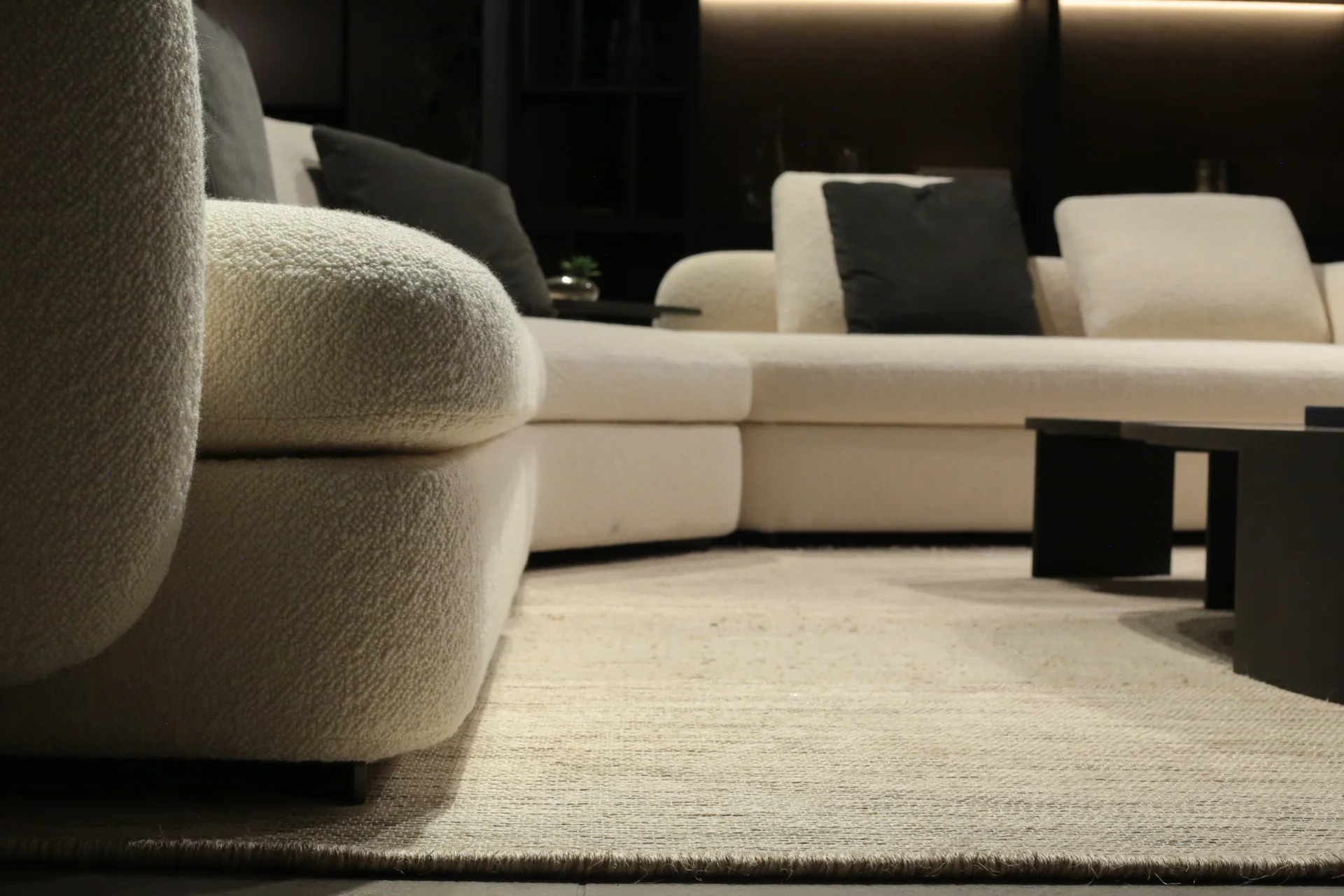 Detalle de sofá Poliform en boucle natural blanco y alfombra tejida en lana cruda · materialidad del lujo silencioso · César Serrano