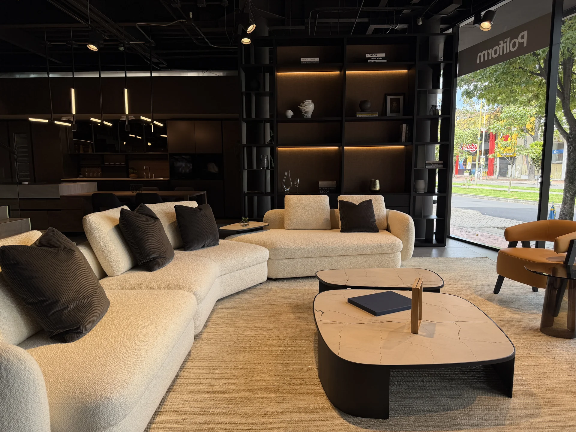 Sala Poliform con sofás modulares y vista al exterior con el logo en la vitrina del showroom de Productos Arquitectónicos en Bogotá