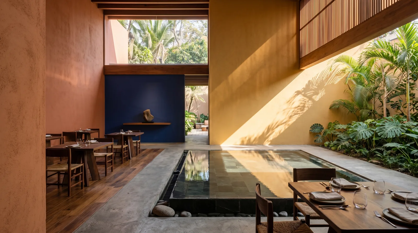 Restaurante en clave de modernismo latino con planos de color y espejo de agua · diseño César Serrano